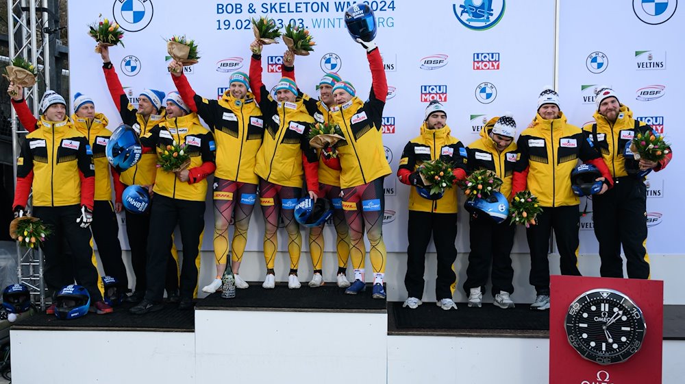 The second-placed team of Johannes Lochner (l), the winning team of Francesco Friedrich (M) and the third-placed team of Adam Ammour, all from Germany, stand on the podium / Photo: Robert Michael/dpa
