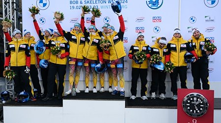 The second-placed team of Johannes Lochner (l), the winning team of Francesco Friedrich (M) and the third-placed team of Adam Ammour, all from Germany, stand on the podium / Photo: Robert Michael/dpa