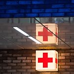 Ein Leuchtkasten mit einem roten Kreuz hängt vor der Notaufnahme eines Krankenhauses. / Foto: Julian Stratenschulte/dpa/Symbolbild