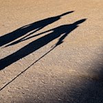 Zwei ältere Personen gehen Hand in Hand mit einem Gehstock über einen Weg und werfen einen langen Schatten. / Foto: Patrick Pleul/dpa-Zentralbild/dpa