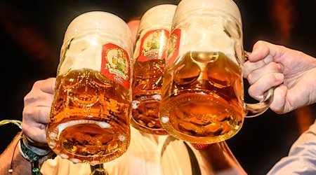 Під час традиційної церемонії відкорковування пива на дрезденському Октоберфесті тостують кухлями пива / Фото: Robert Michael/dpa/Symbolic image