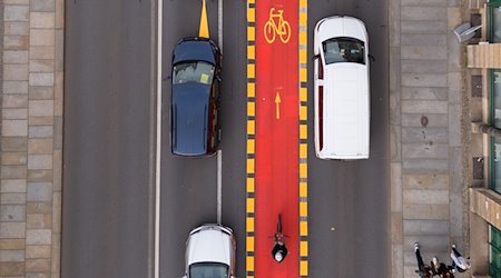 Autos stehen an der Elbbrücke Blaues Wunder an einem rot markierten Radweg. / Foto: Sebastian Kahnert/dpa