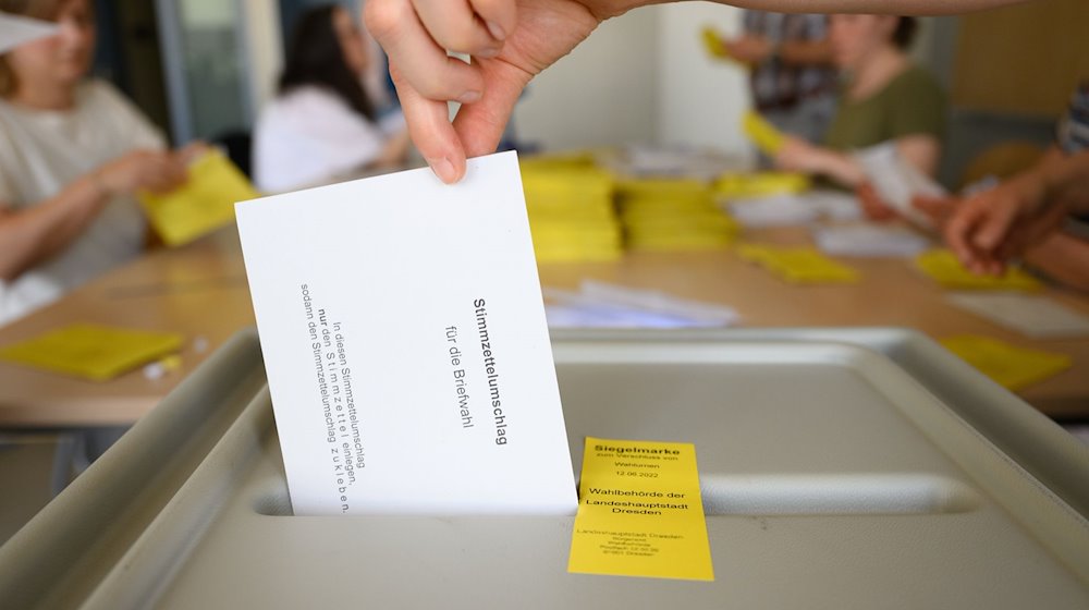 A ballot paper envelope for the postal vote in the mayoral election is dropped into a ballot box in the Bürgerwiese secondary school after all documents have been checked for validity at the postal voting center. The City of Dresden is still looking for polling assistants. / Photo: Robert Michael/dpa