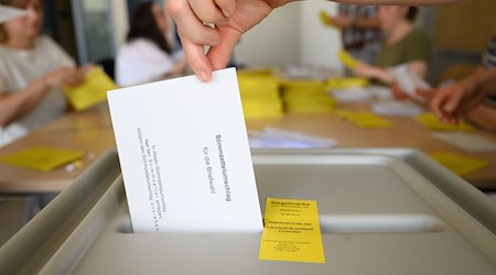 En el centro de voto por correo del colegio Bürgerwiese se deposita un sobre con la papeleta del voto por correo para las elecciones a alcalde, una vez comprobada la validez de todos los documentos. La ciudad de Dresde sigue buscando asistentes electorales. / Foto: Robert Michael/dpa