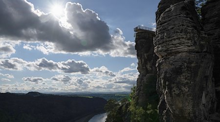 Der neue Aussichtssteg der Bastei zeichnet sich im Elbsandsteingebirge im Nationalpark Sächsische Schweiz im Gegenlicht der Sonne als Silhouette ab. / Foto: Sebastian Kahnert/dpa