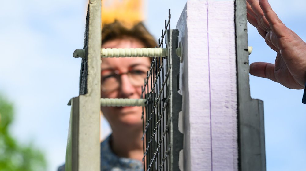 Klara Geywitz (SPD), Bundesministerin für Wohnenbetrachtet während ihres Besuchs in Sachsen auf der Baustelle zum Bau des ersten öffentlichen Gebäudes mit Carbonbeton eine Betonplatte mit Carbon. / Foto: Robert Michael/dpa