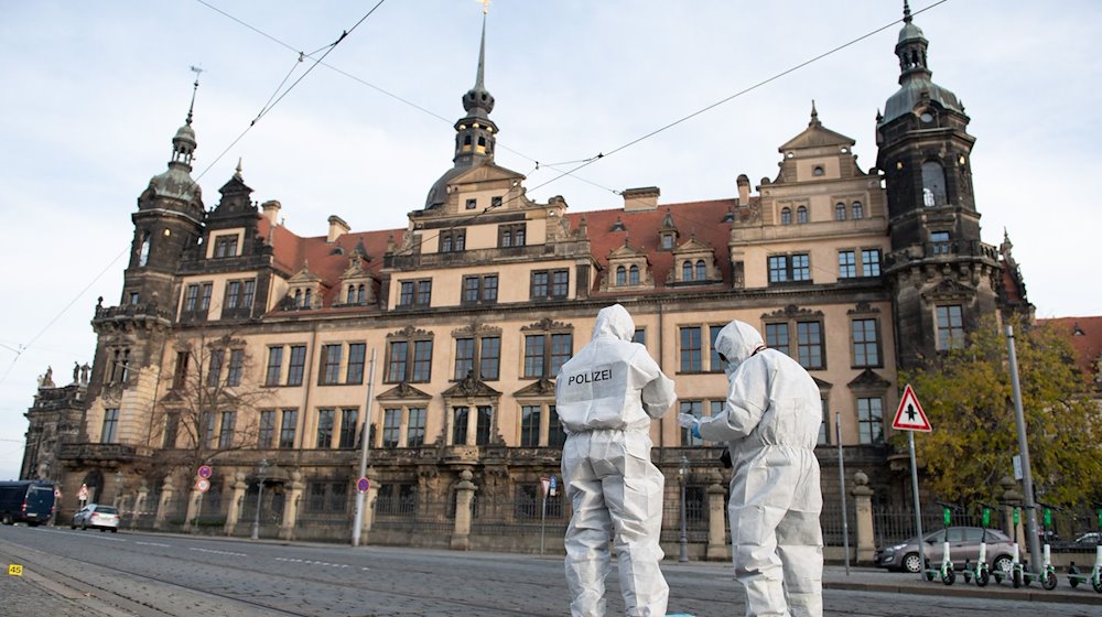 Zwei Mitarbeiter der Spurensicherung stehen vor dem Residenzschloss mit dem Grünen Gewölbe. / Foto: Sebastian Kahnert/dpa