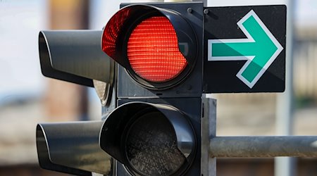 Una flecha verde cuelga junto a un semáforo en rojo en un cruce y permite girar a pesar de la luz roja / Foto: Jan Woitas/dpa-Zentralbild/dpa/Archivbild