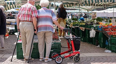 Zwei Senioren stehen mit Gehhilfen und Rollator auf dem Wochenmarkt in der Leipziger Innenstadt. / Foto: Jan Woitas/dpa