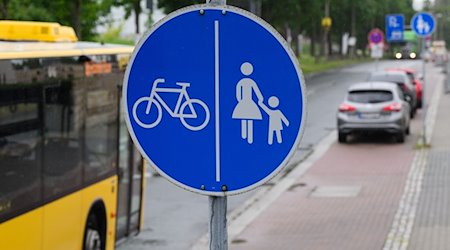 Ein Schild für einen getrennten Rad- und Gehweg steht vor einer Zone, in der das Parken auf halbem Gehweg erlaubt ist. / Foto: Robert Michael/dpa/Symbolbild