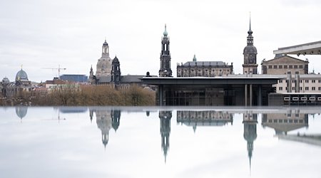 Die Kulisse der Dresdner Altstadt spiegelt sich in einer mit Regenwasser bedeckten Scheibe. / Foto: Sebastian Kahnert/dpa
