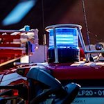 Auf dem Dach eines Einsatzfahrzeugs der Feuerwehr leuchtet ein Blaulicht. / Foto: David Inderlied/dpa/Symbolbild
