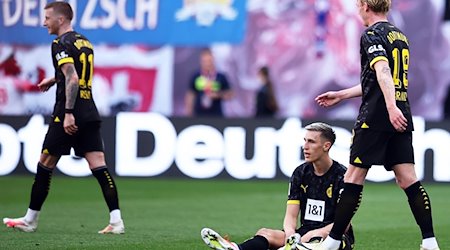 Dortmund's Nico Schlotterbeck (M) reacts next to his teammates Marco Reus (l) and Julian Brandt. / Photo: Jan Woitas/dpa