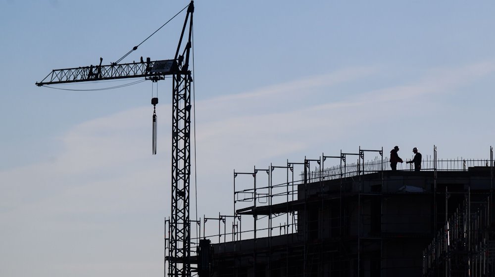 Construction workers stand on the building site of an apartment building / Photo: Julian Stratenschulte/dpa/Symbolic image