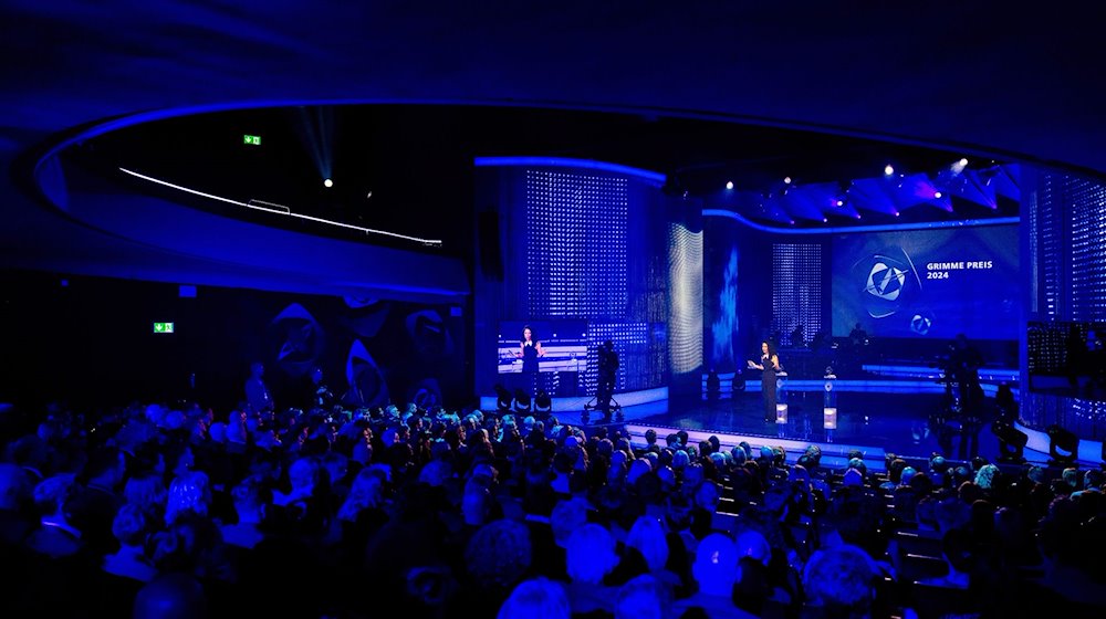 تقف المذيعة سهام الميموني على خشبة مسرح مارل خلال حفل جوائز غريمي 60. / صورة: رولف فينّنبيرند / شركة دبوس ديفولا
