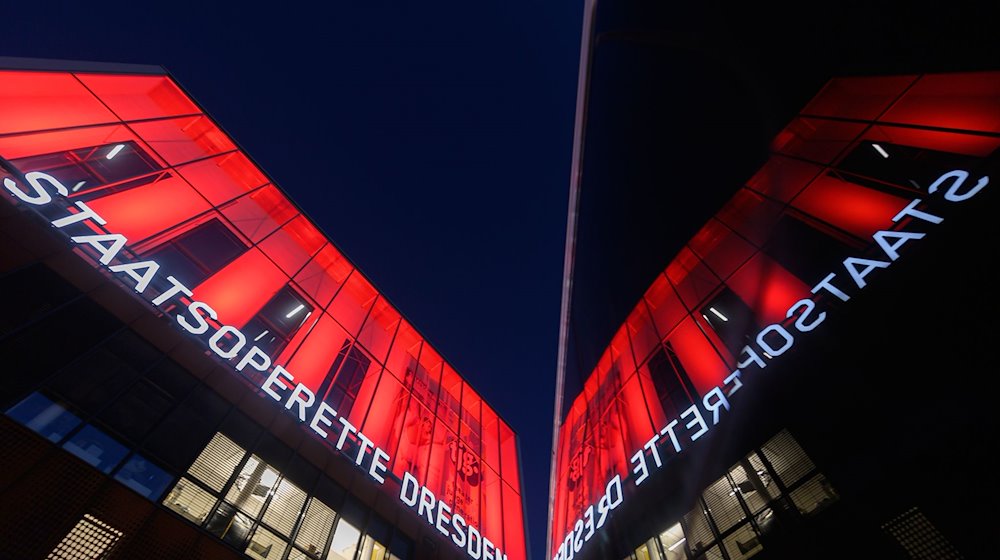 The façade of the Staatsoperette Dresden illuminated in red. / Photo: Robert Michael/dpa-Zentralbild/dpa