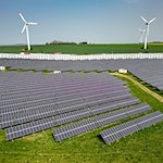 Mehrere Windkraftanlagen stehen hinter einem Solarpark. / Foto: Jan Woitas/dpa/Symbolbild