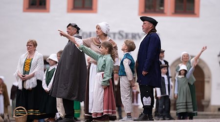 Amateur actors stand on the market square during the re-enactment of Bernardo Bellotto's painting "The Market Square of Pirna" / Photo: Sebastian Kahnert/dpa