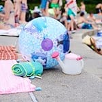 Ein Wasserball und Handtücher liegen in einem Schwimmbad am Beckenrand. / Foto: Annette Riedl/dpa/Symbolbild