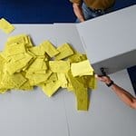 Stimmzettelumschläge für eine Briefwahl werden aus einer Wahlurne geschüttet. / Foto: Robert Michael/dpa/Symbolbild