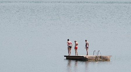 Badegäste stehen im Badesee Birkwitz auf einer Badeinsel. / Foto: Sebastian Kahnert/dpa-Zentralbild/dpa