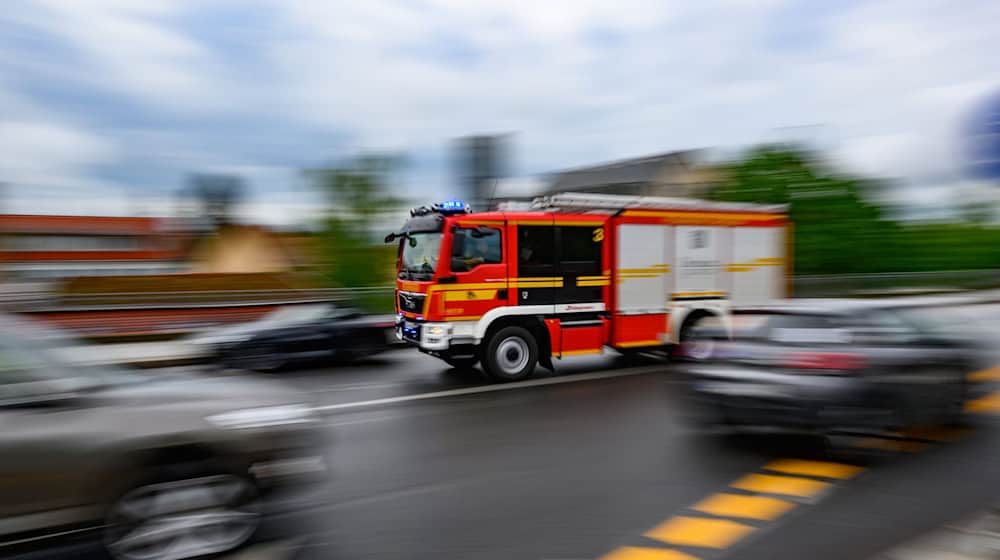 Eine Feuerwehrfahrzeug fährt im Stadtteil Loschwitz mit Blaulicht zu einem Einsatz. (Aufnahme mit langer Belichtungszeit) / Foto: Robert Michael/dpa