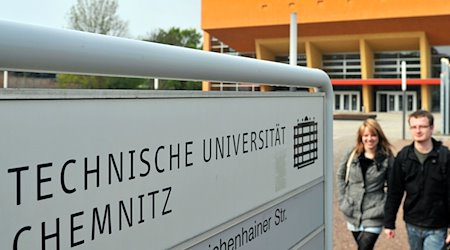 Studenten gehen am zentralen Hörsaalgebäude der Technischen Universität Chemnitz vorüber. / Foto: Hendrik Schmidt/dpa
