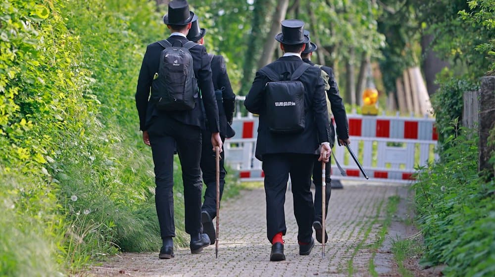 Vier Männer mit Zylinder ziehen mit Wanderstöcken durch den Nordharz. Christi Himmelfahrt geht auf die Apostelgeschichte des Lukas zurück und schließt den Osterkreis ab. / Foto: Matthias Bein/dpa