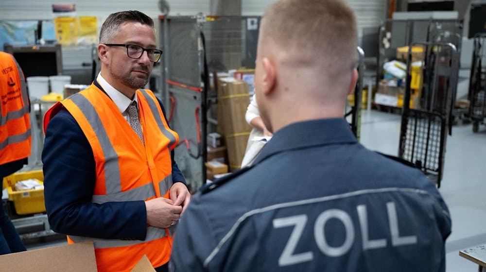 Martin Dulig (SPD, l), Saxony's Minister of Economic Affairs, talks to Leif Gürtler, Senior Customs Secretary, at the DHL hub at Leipzig Airport. The safety of imported products is one of the criteria that customs scrutinizes more closely at the air freight hub. / Photo: Hendrik Schmidt/dpa