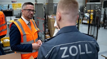 Martin Dulig (SPD, l), Saxony's Minister of Economic Affairs, talks to Leif Gürtler, Senior Customs Secretary, at the DHL hub at Leipzig Airport. The safety of imported products is one of the criteria that customs scrutinizes more closely at the air freight hub. / Photo: Hendrik Schmidt/dpa