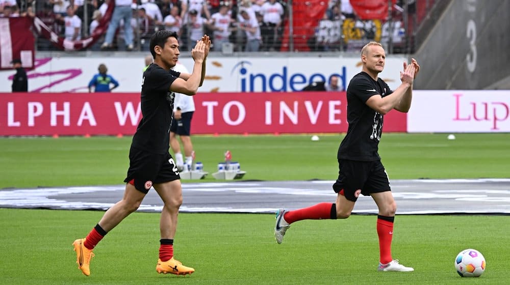 Die beiden Frankfurter Makoto Hasebe (l) und Sebastian Rode kommen vor dem Spiel auf den Platz. / Foto: Arne Dedert/dpa