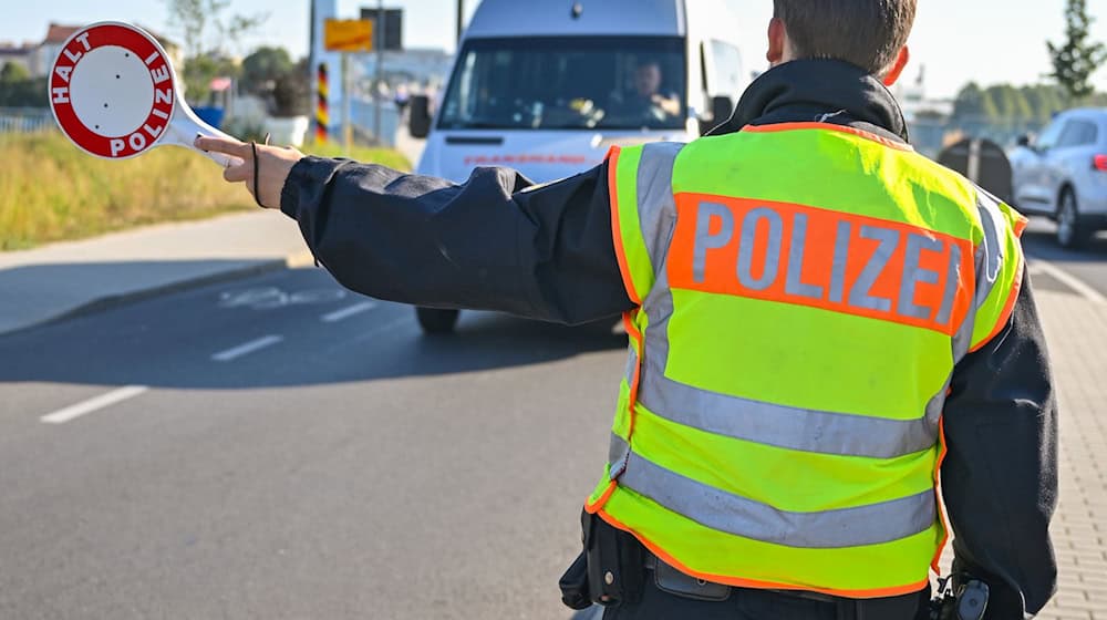 Ein Beamter der Bundespolizei stoppt den Fahrer eines Kleintransporters. / Foto: Patrick Pleul/dpa/Symbolbild