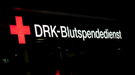Eine Leuchtreklame am Gebäude des Blutspendedienstes des Deutschen Roten Kreuz in Dresden Johannstadt leuchtet am Abend. / Foto: Robert Michael/dpa/Archivbild