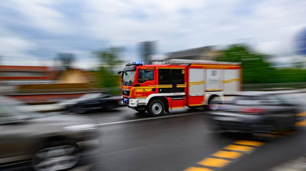 Eine Feuerwehrfahrzeug fährt mit Blaulicht zu einem Einsatz. / Foto: Robert Michael/dpa/Symbolbild