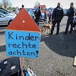 Ein Protestschild mit der Aufschrift "Kinderrechte achten!". / Foto: Heiko Rebsch/dpa/Archiv