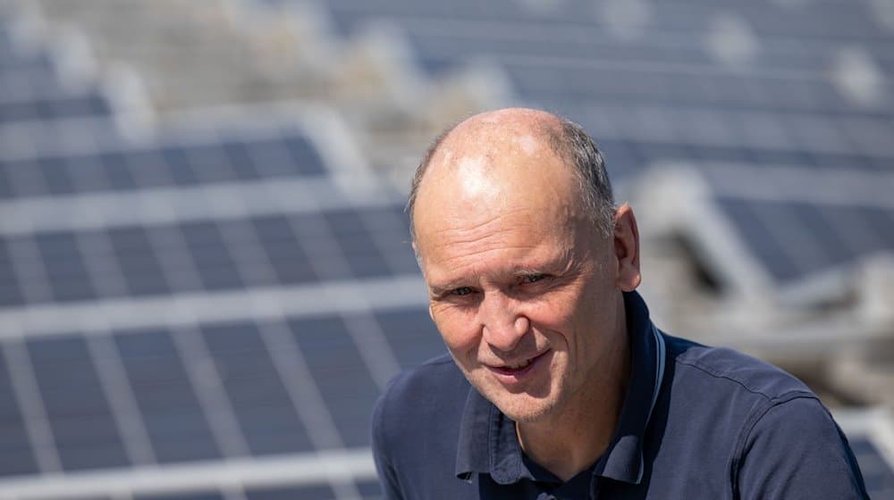 ماتياس جيهلينج، عضو مجلس إدارة التعاونية الطاقوية ليبزيغ، على نظام الطاقة الشمسية على سطح مركز هوبفيلد. / الصورة: هندريك شميدت / دب