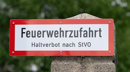 Ein Schild mit der Aufschrift «Feuerwehrzufahrt» steht an einer Einfahrt. / Foto: Sebastian Kahnert/dpa