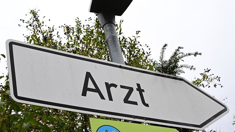 Ein Schild mit der Aufschrift Arzt steht an einer Straße. / Foto: Bernd Weißbrod/dpa