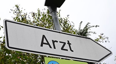 Ein Schild mit der Aufschrift Arzt steht an einer Straße. / Foto: Bernd Weißbrod/dpa