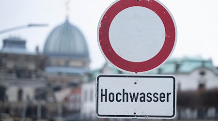 Ein Schild mit der Aufschrift „Hochwasser“ steht am Terrassenufer. / Foto: Sebastian Kahnert/dpa