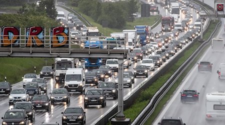 Autos und Lastkraftwagen stauen sich bei Regen auf einer Autobahn. / Foto: Christoph Schmidt/dpa