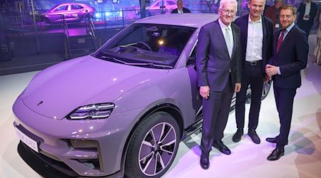 Winfried Kretschmann (l-r, Greens), Minister President of Baden-Württemberg, Porsche CEO Oliver Blume and Michael Kretschmer (CDU), Minister President of Saxony, stand next to an all-electric Porsche Macan at the Leipzig plant at the start of production / Photo: Jan Woitas/dpa