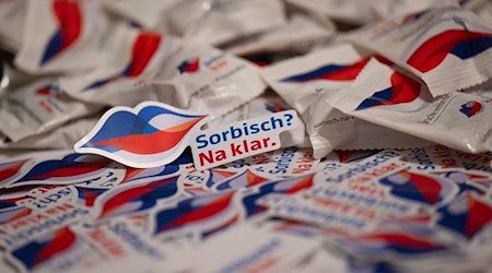 Aufkleber mit der Aufschrift „Sorbisch“ Na klar“ liegen anlässlich der Vogelhochzeit in der Sächsischen Staatskanzlei auf einem Tisch. / Foto: Robert Michael/dpa
