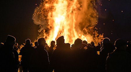 Menschen stehen vor einem Feuer. / Foto: Frank Hammerschmidt/dpa/Symbolbild