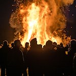 Menschen stehen vor einem Feuer. / Foto: Frank Hammerschmidt/dpa/Symbolbild