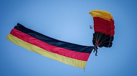Fallschirmspringer der Bundespolizei mit Deutschlandfahne über dem Staatsakt zu «75 Jahre Grundgesetz». / Foto: Kay Nietfeld/dpa