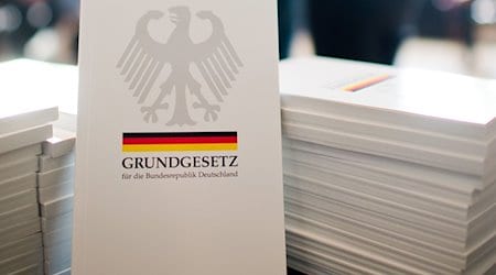 Das Grundgesetz der Bundesrepublik Deutschland liegt bei einer Einbürgerungszeremonie aus. / Foto: Julian Stratenschulte/dpa