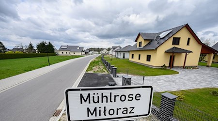 A place name sign stands in front of newly built houses on the street in the so-called Neu-Mühlrose, the new settlement location of Mühlrose / Photo: Robert Michael/dpa
