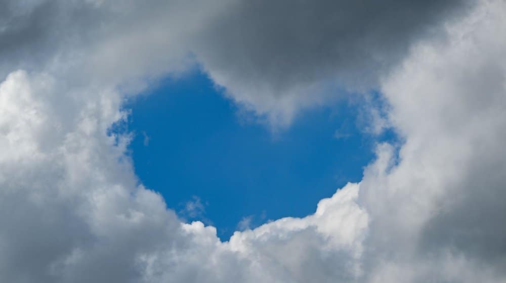 Eine herzförmige Lücke hat sich am Wolkenhimmel aufgetan. / Foto: Arne Dedert/dpa