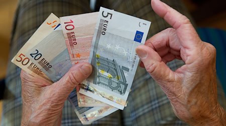 Eine ältere Frau zählt Geld. / Foto: Marijan Murat/dpa/Symbolbild